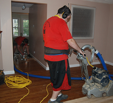 An employee polishing a new hardwood floor installation in Pelham, NH